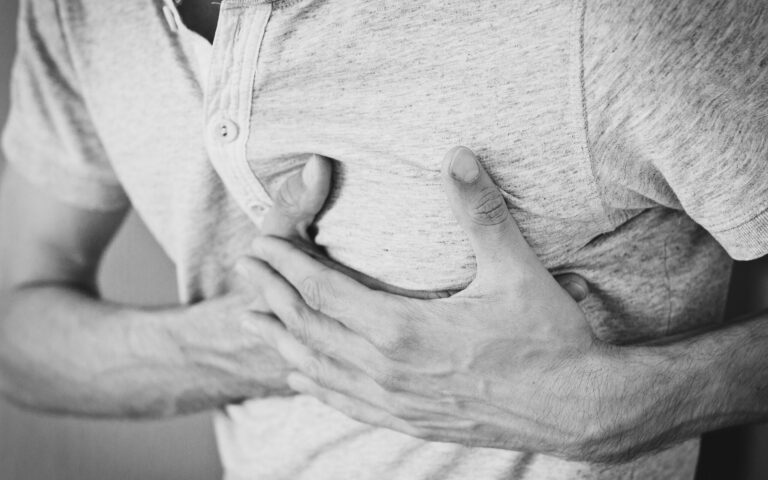 Man Wearing Polo Shirt Holding Left Chest