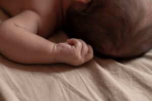 Close-up of a sleeping newborn baby peacefully lying on a soft bed, embodying purity and innocence.